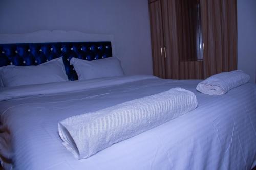 a white bed with two white towels on it at Golden Cozy Homes Limuru in Limuru