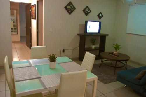 a living room with a dining table and a television at Departamento en Guadalajara in Guadalajara
