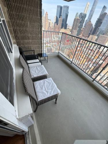 a balcony with two chairs and a couch on a building at Midtown High Floor Fantastic Panoramic City View Corner 2 Bedroom Apartment in New York
