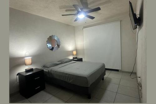 a bedroom with a bed and a ceiling fan at Departamento en Guadalajara in Guadalajara