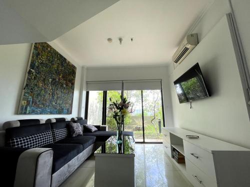 a living room with a couch and a tv at Cosmo Park Town House in Jakarta