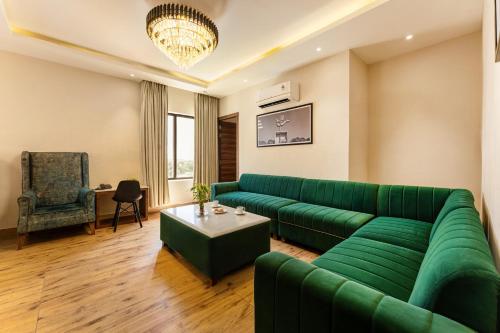 a living room with a green couch and a table at Medalio Boutique Chandigarh Zirakpur in Zirakpur