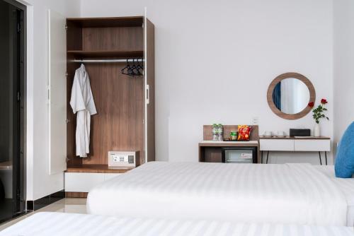 a bedroom with a white bed and a mirror at Sunora Villa Hoi An in Hoi An