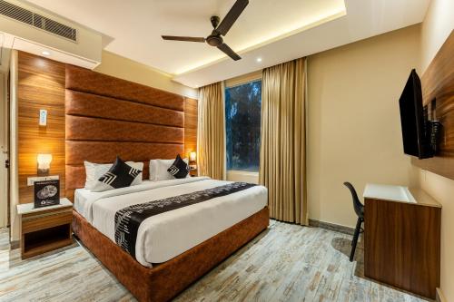 a bedroom with a bed and a flat screen tv at Medalio Boutique Chandigarh Zirakpur in Zirakpur