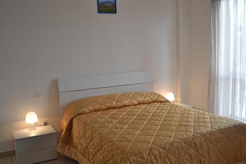 um quarto com uma cama e duas luzes numa mesa de cabeceira em Camere I Monelli em Assis