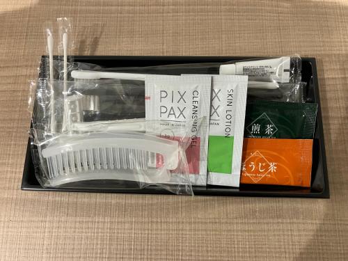 a plastic box with a toothbrush and other items at Smile Hotel Okayama in Okayama