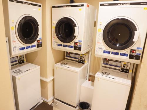 a laundry room with three washer and dryers at APA Hotel Hachinohe Chuo in Hachinohe