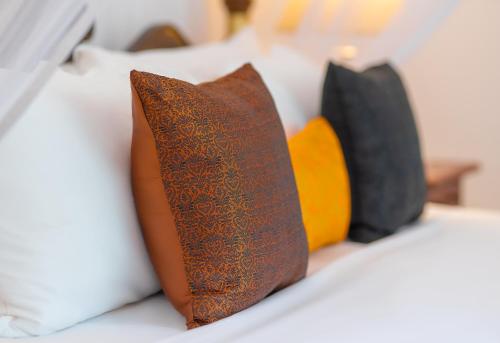 a row of pillows sitting on a bed at Adigars Manor in Kandy