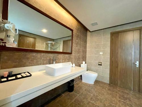 a bathroom with a sink and a toilet and a mirror at Muong Thanh Grand Xa La Hotel in Hanoi