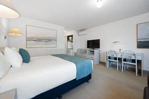 a bedroom with a bed and a desk and a television at Comfort Inn Devonport in Devonport