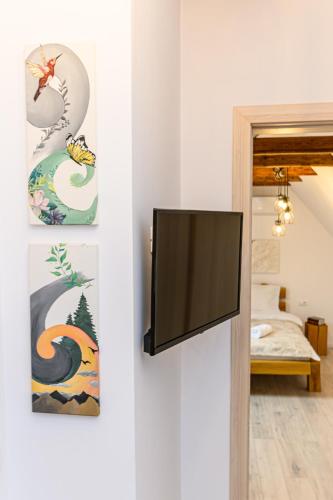 a flat screen tv hanging on a wall in a room at B-Holiday Luxury GuestHouse in Prejmer