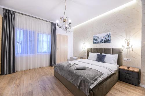 a bedroom with a large bed and a large window at B-Holiday Luxury GuestHouse in Prejmer