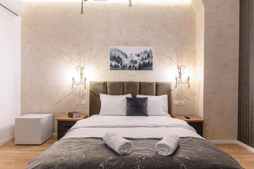 a bedroom with a large bed with two night stands at B-Holiday Luxury GuestHouse in Prejmer