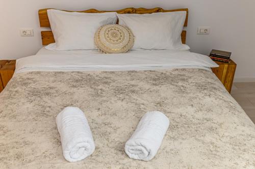 a bed with two white towels on it at B-Holiday Luxury GuestHouse in Prejmer