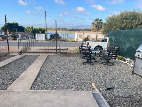 a fence with two chairs and a truck parked in a yard at Casa con vista al estero in Ensenada