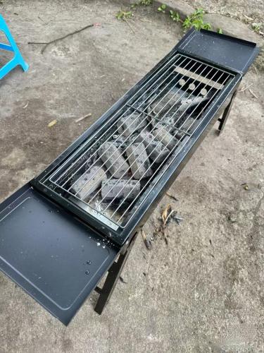 a black grill sitting on top of the ground at Xianxiuju Garden Courtyard B&B in Fenghuang