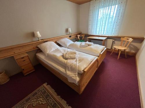 a bedroom with two beds and a table and a window at Bad Bruckhaus Erlebnishotel in Waldshut-Tiengen