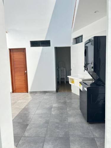 a room with a kitchen with a tv and a microwave at Casa de Campo VIP San Andrés in San Andrés