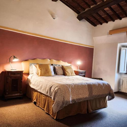 una camera da letto con un letto e una parete rossa di A painting for each window with AIR CONDITIONING! a Siena