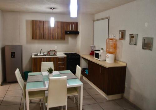 a kitchen with a table and chairs and a kitchen with a table and a counter at Departamento en Guadalajara in Guadalajara