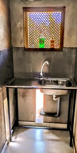 a kitchen with a sink and a window at Bee Line Holiday Apartment in Dickwella