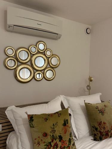 a mirror on a wall above a bed with pillows at Casa CARLU-MARIA IV in Corte