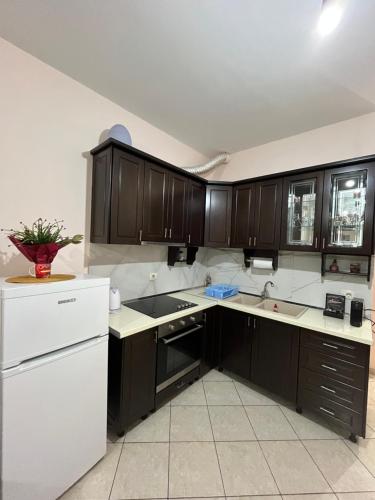 una cucina con mobili marroni e un frigorifero bianco di Studio Utopia a Vlorë