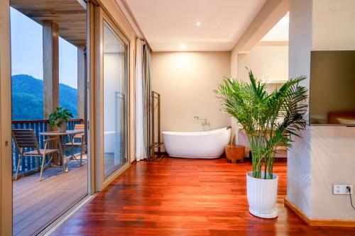 a bathroom with a bath tub and a balcony at Xianxiuju Garden Courtyard B&B in Fenghuang