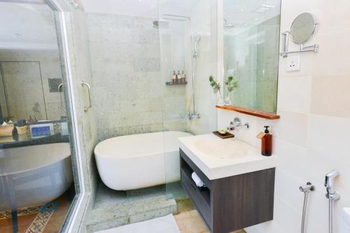 a bathroom with a tub and a sink and a shower at Sojourn Spa Hotel Melaka in Melaka