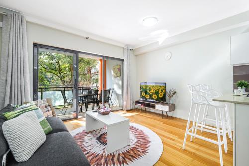 a living room with a couch and a table at Comfy 2-bedroom 2-balcony apartment Close to CBD, Train and Metro easy reach in Sydney