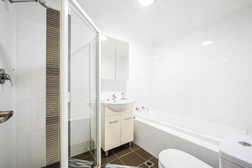 a white bathroom with a sink and a toilet at Comfy 2-bedroom 2-balcony apartment Close to CBD, Train and Metro easy reach in Sydney