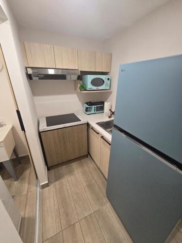 a small kitchen with a refrigerator and a microwave at Apartment in Torre Artemisa in Tegucigalpa