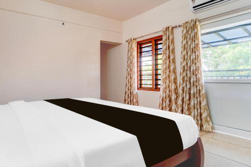 a bedroom with a white bed and a window at Super Townhouse Kalady Near Airport in Cochin