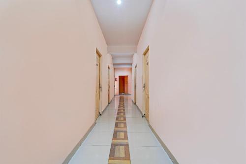 a corridor of an empty hallway with white walls and floors at Super Hotel O Anna Nagar Madurai in Madurai