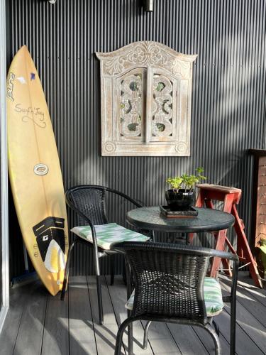 a table and chairs and a surfboard on a wall at Surf'n'Joe luxury one bedroom suite in Palm Beach