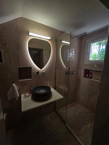 a bathroom with a sink and a shower with a mirror at Tamarisk House-An Ideal Getaway in Southern Paros in Márpissa