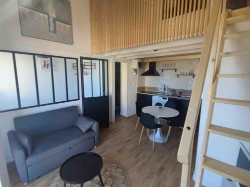 un salon avec un canapé et une table et une cuisine dans l'établissement Superbe appartement quartier Arago, proche remblai, à Les Sables-dʼOlonne