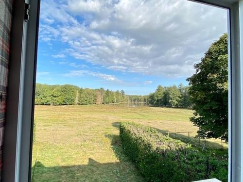 a view of a field from a window at Gîte du Parc Animalier de Boutissaint in Treigny