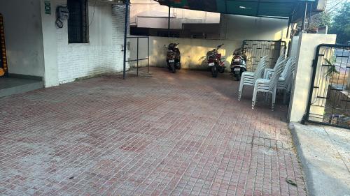 two motorcycles parked outside of a building with chairs at Vizag Comforts in Visakhapatnam
