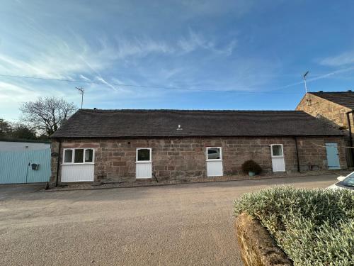 a brick building with two white doors and a roof at The Old Parlour in Alton
