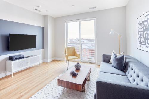 a living room with a couch and a tv at The Frankford Fishtown in Philadelphia