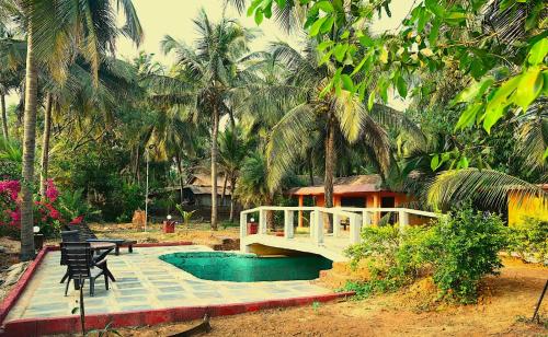 un puente sobre una piscina frente a una casa en Koral Islands Homestay, en Sadāshivgarh