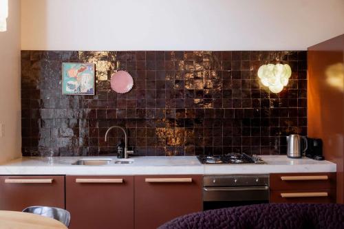a kitchen with a sink and a stove top oven at A luxe stay in the Paris end of Melbourne in Melbourne