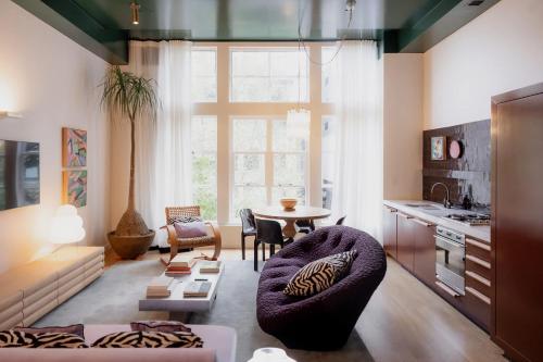 a living room with a table and a kitchen at A luxe stay in the Paris end of Melbourne in Melbourne