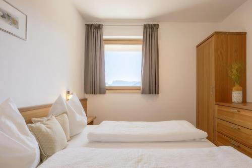 a bedroom with two white beds and a window at Egarter in Appiano sulla Strada del Vino