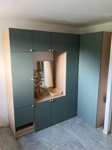 un placard avec des armoires vertes et un miroir dans l'établissement Chalet christophe, à Chamonix-Mont-Blanc