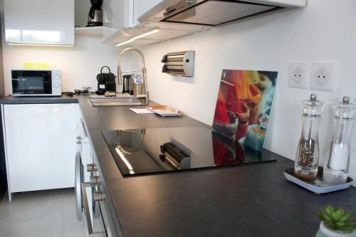 une cuisine avec un comptoir noir dans une pièce dans l'établissement Lyloa - terrasse - plage - garage - climatisation- et tranquillité, à Six-Fours-les-Plages