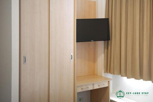 a cabinet with a television on it in a room at Famous Hotel Melbourne CBD in Melbourne
