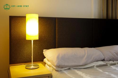 a bedroom with a bed with a lamp on a table at Famous Hotel Melbourne CBD in Melbourne