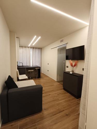 a living room with a black couch and a desk at [Riviera Apartments] Near the beach + Parking in Rosolina Mare